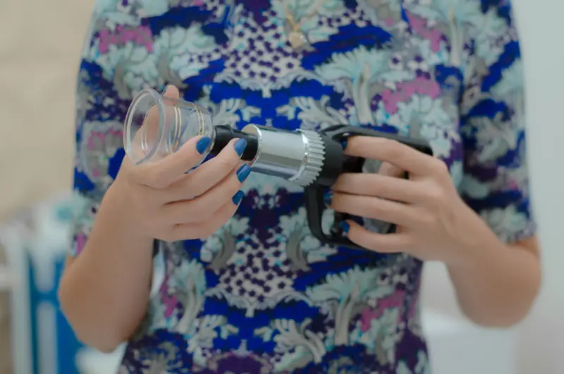 Detalhe de equipamento de estética nas mãos de uma profissional